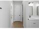 Hallway with white walls and trim, leading to rooms, and showing the hardwood floors at 15504 Melport Cir, Port Charlotte, FL 33981