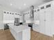 Well-appointed kitchen featuring modern white cabinetry, a spacious island, and sleek stainless steel appliances at 15504 Melport Cir, Port Charlotte, FL 33981