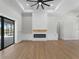 Open living room featuring a decorative fireplace, built-ins, and access to screened outdoor pool at 15504 Melport Cir, Port Charlotte, FL 33981