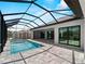 Beautiful private pool and spa with a screened-in enclosure leading to a covered outdoor living space at 15504 Melport Cir, Port Charlotte, FL 33981