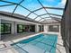 Relaxing pool and patio area features screened enclosure and views of home's interior at 15504 Melport Cir, Port Charlotte, FL 33981