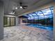 Covered lanai overlooking the water, featuring a luxurious pool and a spacious outdoor living area at 15504 Melport Cir, Port Charlotte, FL 33981