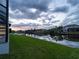 The backyard of the house is waterfront property with a dock for a boat and luscious grass at 15504 Melport Cir, Port Charlotte, FL 33981