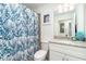 Bathroom featuring a blue patterned shower curtain, granite countertop, and a well-lit mirror at 15990 Grassland Ln # 3024, Punta Gorda, FL 33982