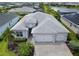 Beautiful aerial view of home, showcasing the three-car garage, paver driveway and landscaping at 17556 Winding Wood Ln, Punta Gorda, FL 33982