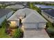 Beautiful aerial view of home, showcasing the three-car garage, paver driveway and landscaping at 17556 Winding Wood Ln, Punta Gorda, FL 33982