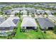 Aerial view of a manicured lawn and backyard patio overlooking a lake at 17556 Winding Wood Ln, Punta Gorda, FL 33982