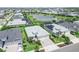 Aerial view of a property with a well-manicured lawn and a lake view at 17556 Winding Wood Ln, Punta Gorda, FL 33982