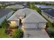 Aerial view of the house showing the three-car garage and paver driveway and professional landscaping at 17556 Winding Wood Ln, Punta Gorda, FL 33982