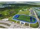 Aerial view of well-maintained athletic fields, including a baseball diamond and a football field with running track at 17556 Winding Wood Ln, Punta Gorda, FL 33982
