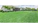 Spacious backyard with lush green grass, trimmed bushes, and a covered patio at 17556 Winding Wood Ln, Punta Gorda, FL 33982
