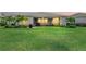 Large backyard with lush landscaping, green lawn, and a covered lanai at 17556 Winding Wood Ln, Punta Gorda, FL 33982