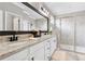 Stylish bathroom featuring double sinks, granite countertops, white cabinets, and a glass-enclosed shower at 17556 Winding Wood Ln, Punta Gorda, FL 33982