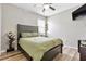 Cozy bedroom features wood flooring, ceiling fan, window, and stylish furniture including a king bed and bookcase at 17556 Winding Wood Ln, Punta Gorda, FL 33982