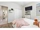 Bright bedroom with wood floors, closet, a television, and modern decor for a comfortable and relaxing space at 17556 Winding Wood Ln, Punta Gorda, FL 33982