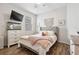 Stylish bedroom features wood flooring, a TV, a dresser with fish tank and a queen bed with plush blankets at 17556 Winding Wood Ln, Punta Gorda, FL 33982
