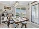 Charming dining area with a coffee bar, rustic table, and natural light from a large window at 17556 Winding Wood Ln, Punta Gorda, FL 33982