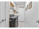 Well-organized laundry room featuring a modern washer and dryer, built-in shelves, and stylish decor at 17556 Winding Wood Ln, Punta Gorda, FL 33982