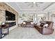 Spacious living room featuring stone accent wall with fireplace, tile floors, comfortable leather seating, and modern fixtures at 17556 Winding Wood Ln, Punta Gorda, FL 33982