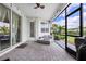 Enclosed patio with brick flooring and comfortable gray seating under string lights, providing a cozy outdoor space at 17556 Winding Wood Ln, Punta Gorda, FL 33982