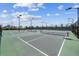 Outdoor tennis courts with lighting for evening games and a dark green fence at 17556 Winding Wood Ln, Punta Gorda, FL 33982