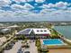 Aerial view featuring the community center with solar panels, pool, parking and a view of the lake at 17924 Corkwood Bend Trl, Punta Gorda, FL 33982