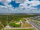 This aerial view shows baseball and soccer fields near homes and a lake at 17924 Corkwood Bend Trl, Punta Gorda, FL 33982