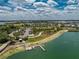Aerial view of lakefront amenities including pier access, lush green spaces, and community parking at 17924 Corkwood Bend Trl, Punta Gorda, FL 33982