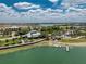 Aerial view of the lakeside community center featuring outdoor seating, a pier, and lush landscaping at 17924 Corkwood Bend Trl, Punta Gorda, FL 33982