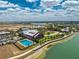 Aerial view showcasing the community center with a pool, ample parking, and a scenic lake backdrop at 17924 Corkwood Bend Trl, Punta Gorda, FL 33982