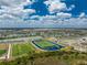 Aerial view of neighborhood with pristine athletic fields, sports facilities, and picturesque lake views at 17924 Corkwood Bend Trl, Punta Gorda, FL 33982