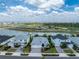 Aerial view showcasing a residential street with lakefront properties and a vibrant sports complex at 17924 Corkwood Bend Trl, Punta Gorda, FL 33982