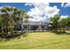 Palm trees and green grass backyard with view of screened in pool and back of house at 17924 Corkwood Bend Trl, Punta Gorda, FL 33982