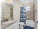 Full bathroom featuring granite countertop, tiled shower and tub, and a blue shower curtain at 17924 Corkwood Bend Trl, Punta Gorda, FL 33982