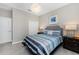 Cozy bedroom with a blue and grey striped bedspread and a decorative chandelier at 17924 Corkwood Bend Trl, Punta Gorda, FL 33982