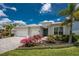 A lush, landscaped front yard complements the home's three-car garage and neutral-toned exterior at 17924 Corkwood Bend Trl, Punta Gorda, FL 33982