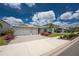 Exterior elevation view of home with three-car garage, landscaped garden with pink flowers at 17924 Corkwood Bend Trl, Punta Gorda, FL 33982