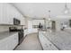 Bright kitchen with stainless steel appliances, granite counters, and white cabinetry and a large island at 17924 Corkwood Bend Trl, Punta Gorda, FL 33982