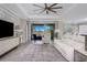 Bright living room with ceiling fan and glass doors to patio with pool views at 17924 Corkwood Bend Trl, Punta Gorda, FL 33982