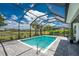 The screened pool offers serene lake views and is surrounded by lush landscaping at 17924 Corkwood Bend Trl, Punta Gorda, FL 33982
