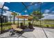 A screened-in pool with lounge chairs overlooking a scenic lake at 17924 Corkwood Bend Trl, Punta Gorda, FL 33982