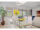 Modern dining room with glass table, white chairs, and view of the outdoor living space at 1993 E Isles Rd, Port Charlotte, FL 33953