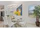 Bright dining room with a glass table, white chairs, modern lighting, and stylish décor at 1993 E Isles Rd, Port Charlotte, FL 33953