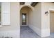 Covered front entry features a tiled floor, a dark wood door with glass, and an exterior light fixture at 1993 E Isles Rd, Port Charlotte, FL 33953
