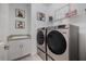 Efficient laundry room featuring modern washer and dryer, practical sink, and storage solutions at 1993 E Isles Rd, Port Charlotte, FL 33953