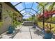 Covered screened patio with hot tub, dining area, and landscaping at 1993 E Isles Rd, Port Charlotte, FL 33953