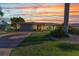 Beautiful sunset illuminates this waterfront property with lush landscaping and a brick paved driveway at 2100 Via Esplanade, Punta Gorda, FL 33950