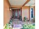 Inviting front door with decorative glass and sidelights surrounded by lush landscaping at 2100 Via Esplanade, Punta Gorda, FL 33950
