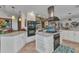 Stylish kitchen includes an island with cooktop, white cabinetry, and stainless steel range hood at 2100 Via Esplanade, Punta Gorda, FL 33950