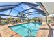 A screened-in pool features a brick surround and sunny views of the waterfront neighborhood at 2100 Via Esplanade, Punta Gorda, FL 33950